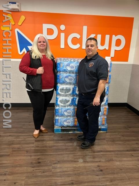 Walmart Manager Jessica McCoombs stands with Watch Hill Fire Marshal Chris Moore as they donate a pallet of drinking water to our department. 