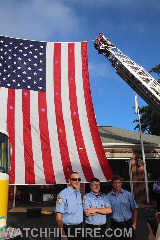 FF Majeika, Meyer, and Esposito in front of the ladder flag