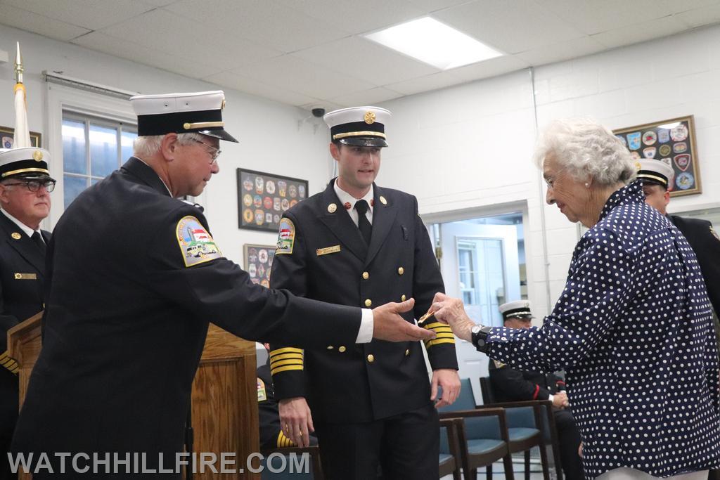 WHFD Chaplain Cal Lord hands Mrs. Betty Cugini, Grandmother of AC Koretski his badge