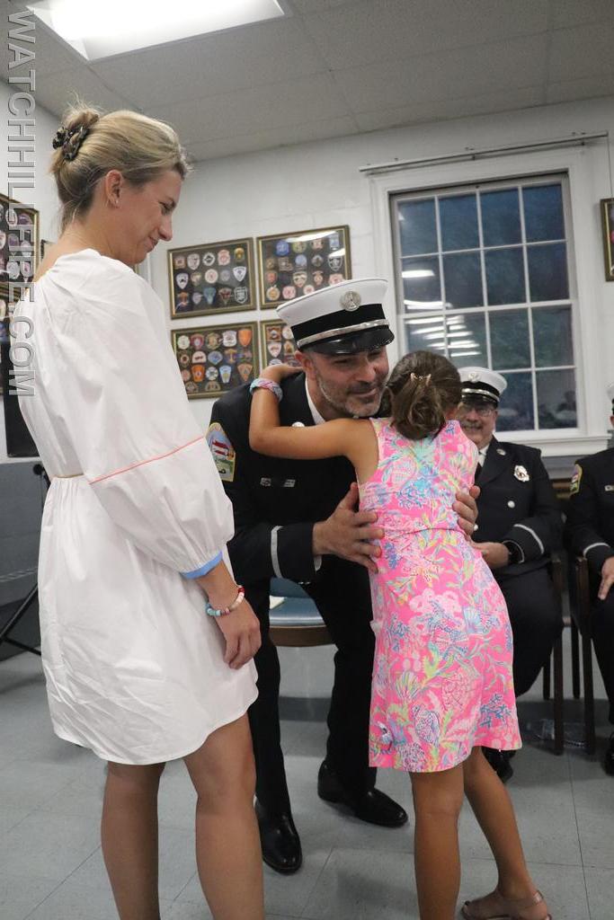 Lieutenant James Nicholas has his badge pinned on by his daughter Ellen while his wife Dr. Emery Nicholas looks on
