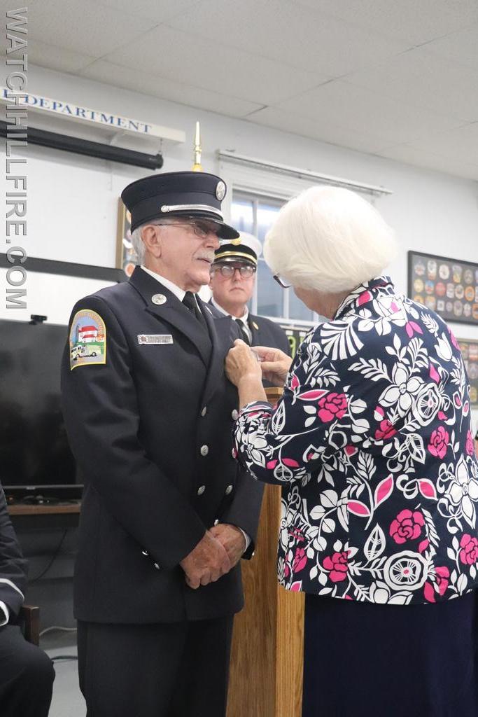 Fire Police Sergeant Bob Perkins has his badge pinned by his wife, Sharon