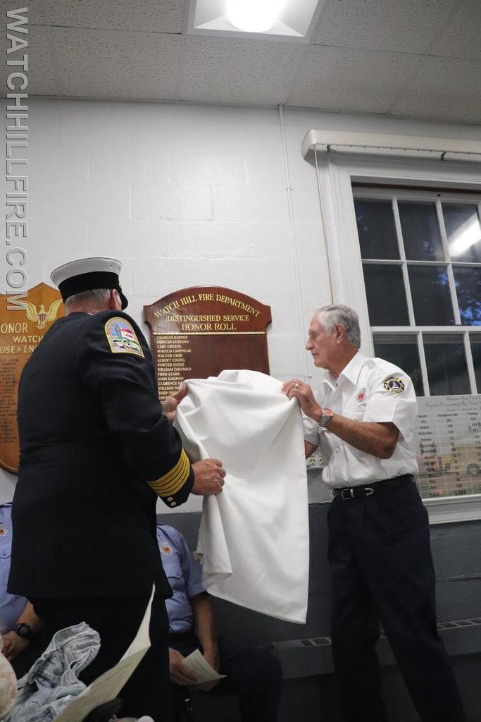 Chief Harold and LT Murphy unveil the Distinguished Service Honor Roll Plaque in the meeting room