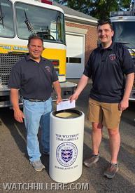 Chief Reall and Lieutenant Rees Harold add the WHFD’s contributions to the time capsule. 